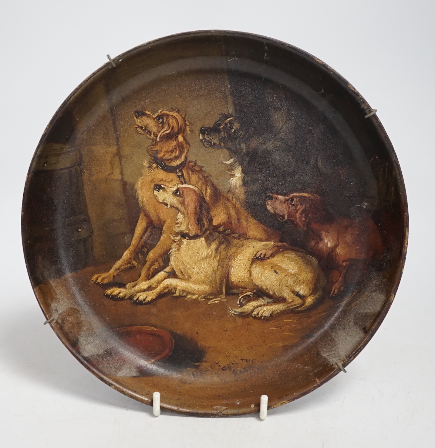 A late 19th century painted papier mache dish, Ready for the Sport, decorated with seated spaniels, 21cm